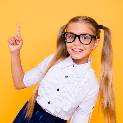 smiling girl with glasses pointing up wearing a ruffled white shirt on a yellow background idea expression learning